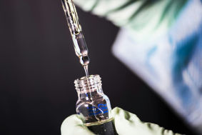 A syringe being placed into a vial