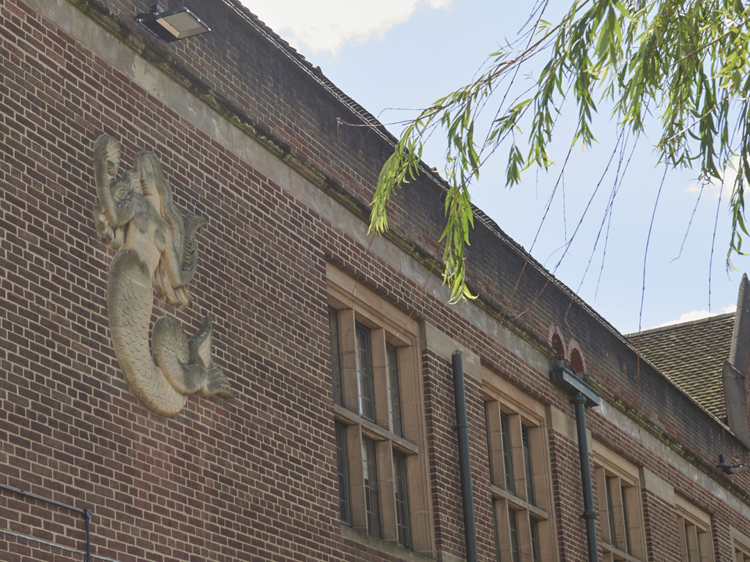 Stone carved Mermaid Relief by William Bloye in context set into wall of Guild of Students