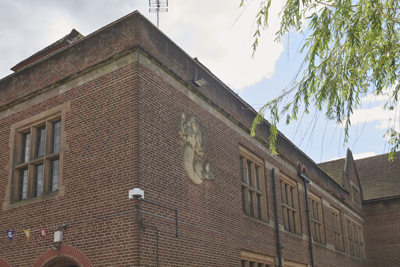 Stone carved Mermaid Relief by William Bloye in context set into wall of Guild of Students