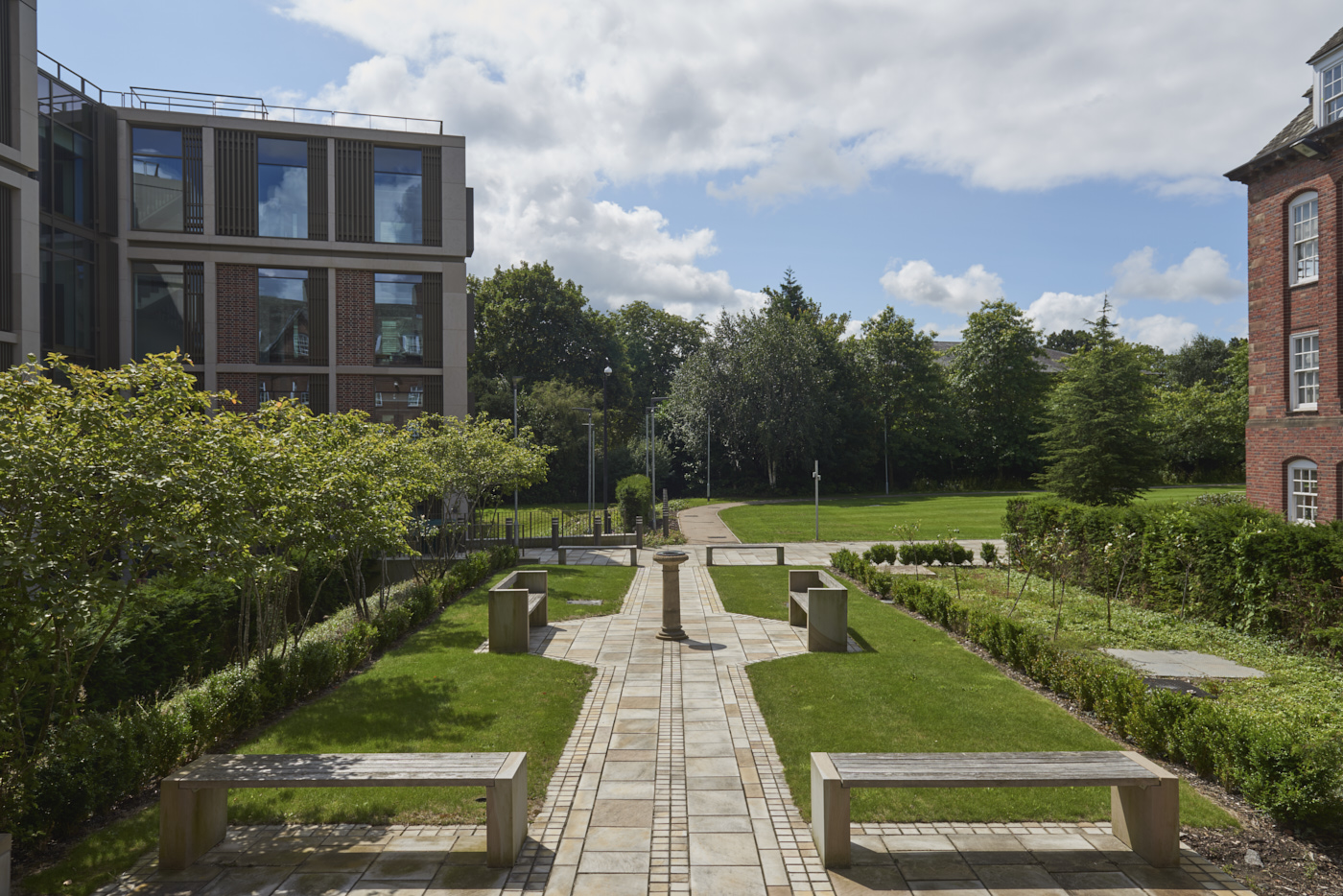 Stone birdbath with ornate lead inner bowl in context of University House/Business School garden