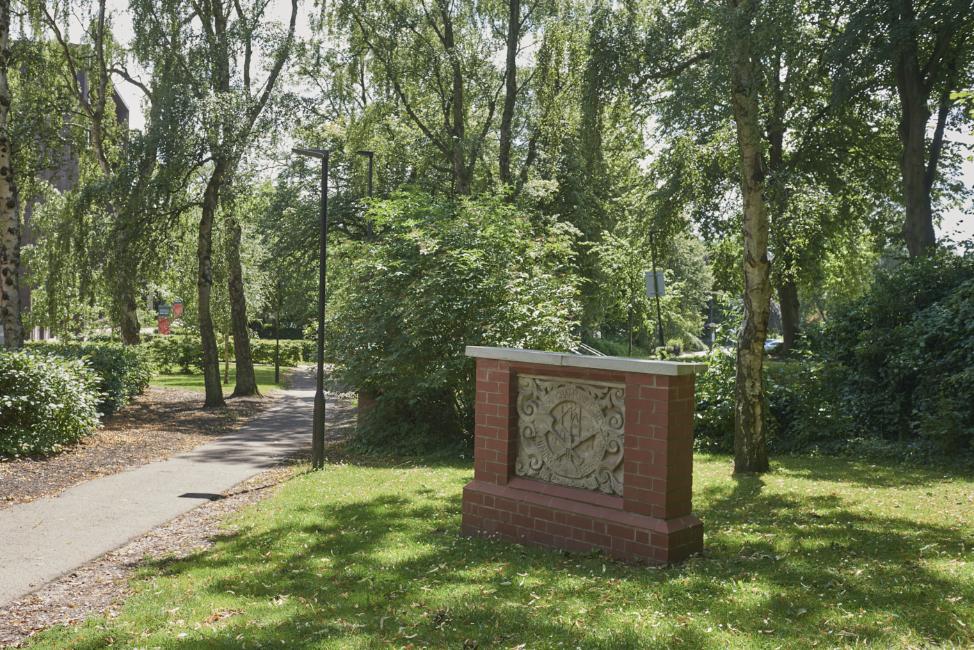 Carved stone heraldic shield from the Mining Department in context of University grounds