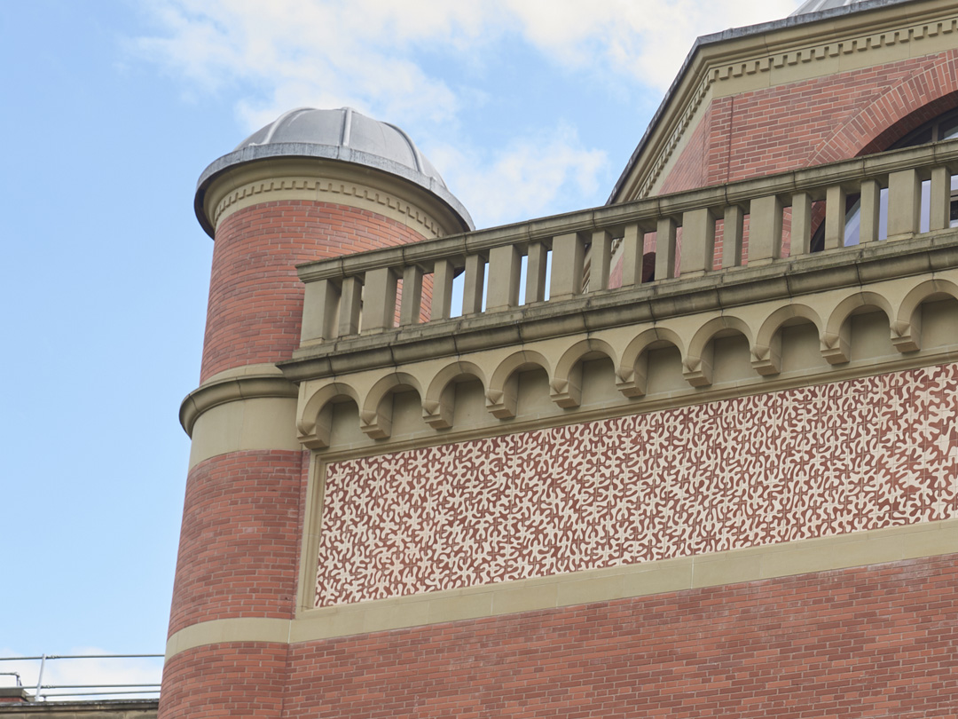 Left side close up of Theme and Variation ceramic frieze by Peter Randall-Page with corner turret of Bramall Music Building