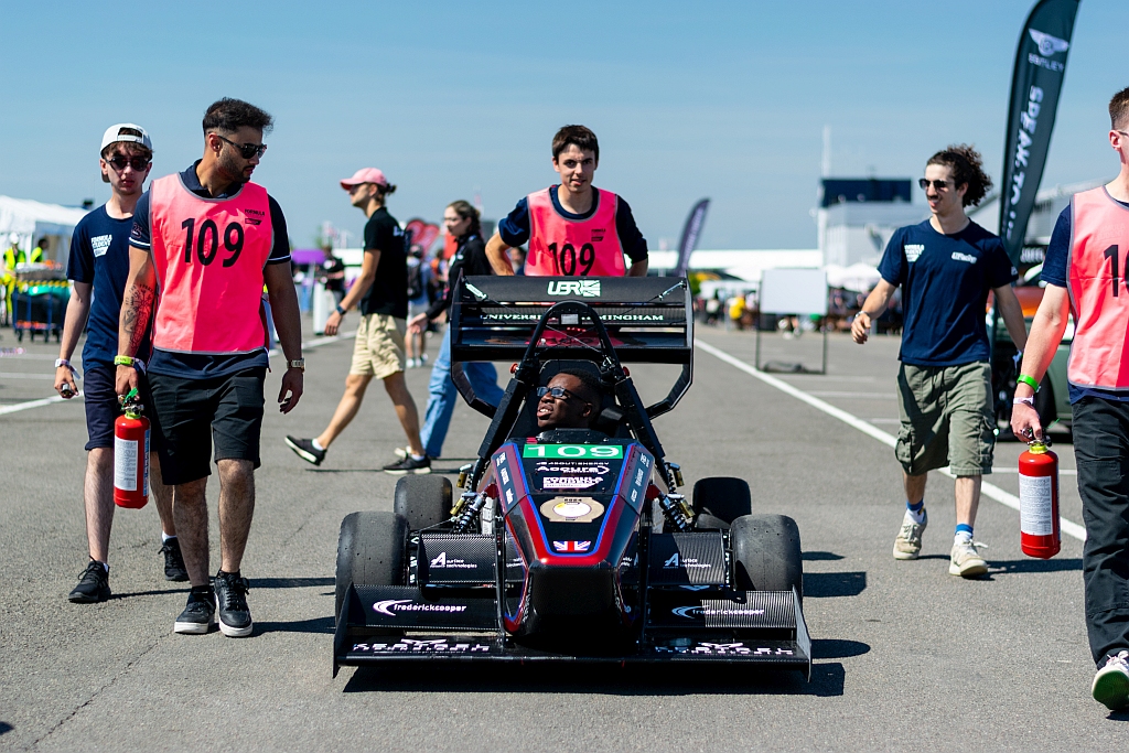 The team walking with the UBRacing racing car