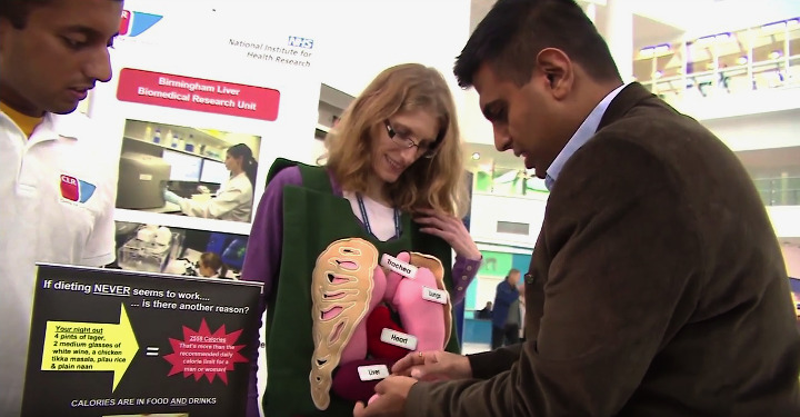  Woman and man on liver public involvement stall engaging with a member of the public 