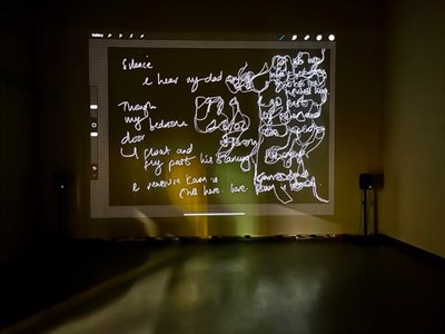 A projection of doodles on a wall in a dark room.