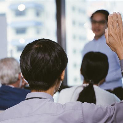 a man raises his hand at a small seminar