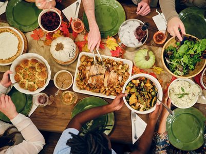 An aerial view of a group of people taking food from dishes on a table