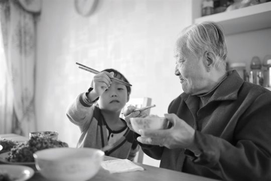 Image of child and grandparent eating with chopsticks