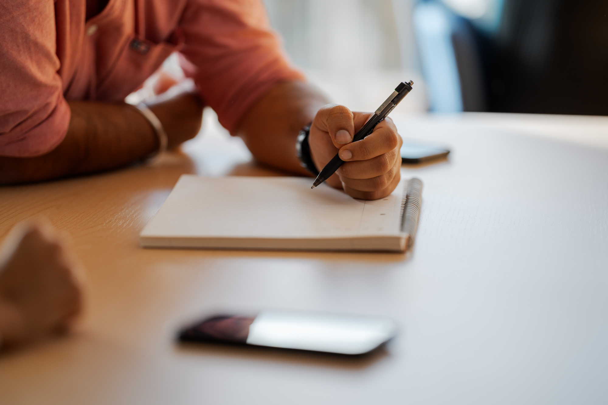 A person writing on a notepad.