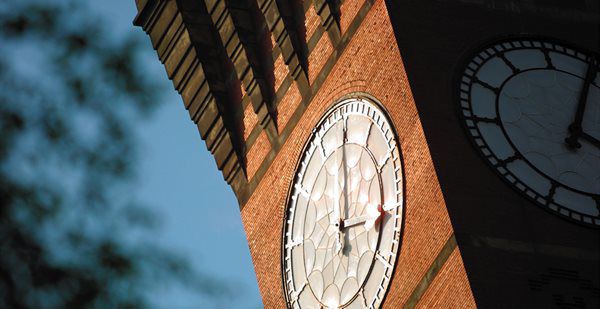 A close-up photo of a red-brick clock tower.