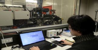 A researcher working in a vehicle technology lab on a laptop