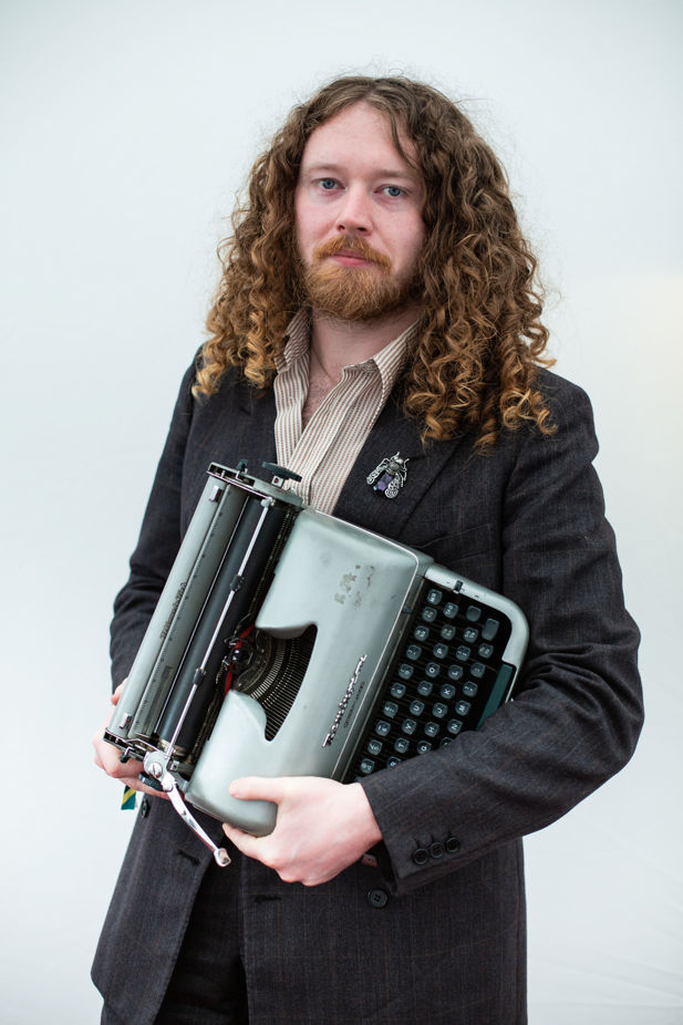 Poet Bradley Taylor poses with his typewriter.