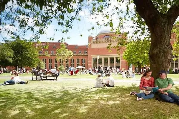 Students sat on grass in Aston Webb on the Green Heart