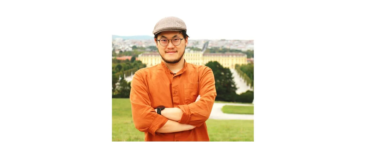 Lei Zhang in an orange shirt with arms folded