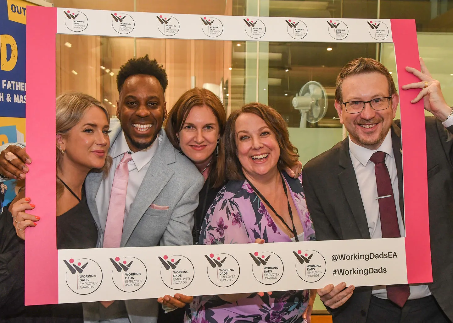  A group of people at the Working Dads Employers Awards holding a branded frame around themselves