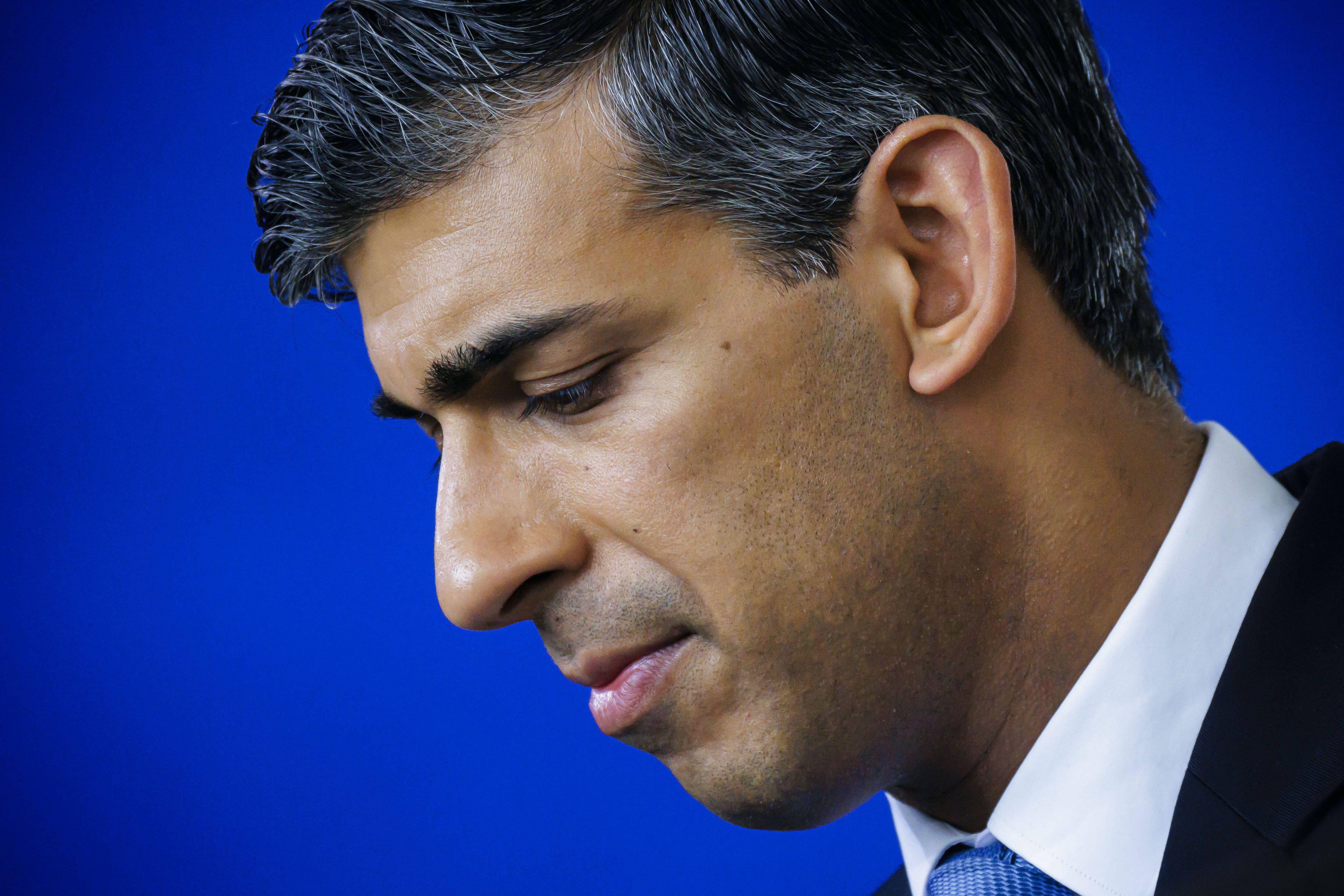 Rishi Sunak, Prime Minister and leader of the Conservative Party, in profile looking sad.