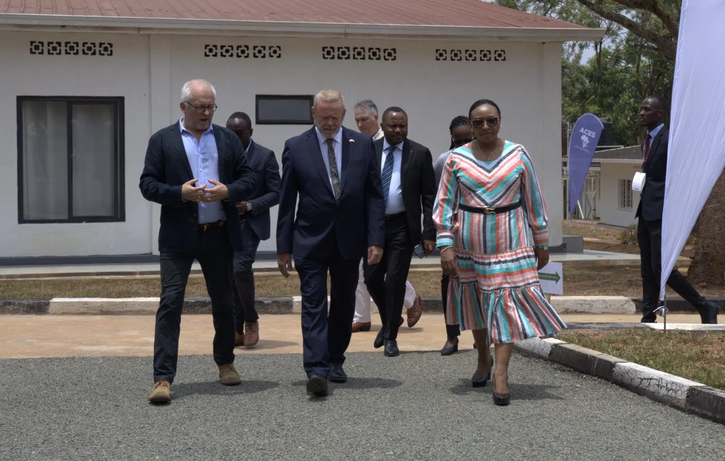 A University of Birmingham academic talking to a UK Lord Minister and Rwandan Minister while walking