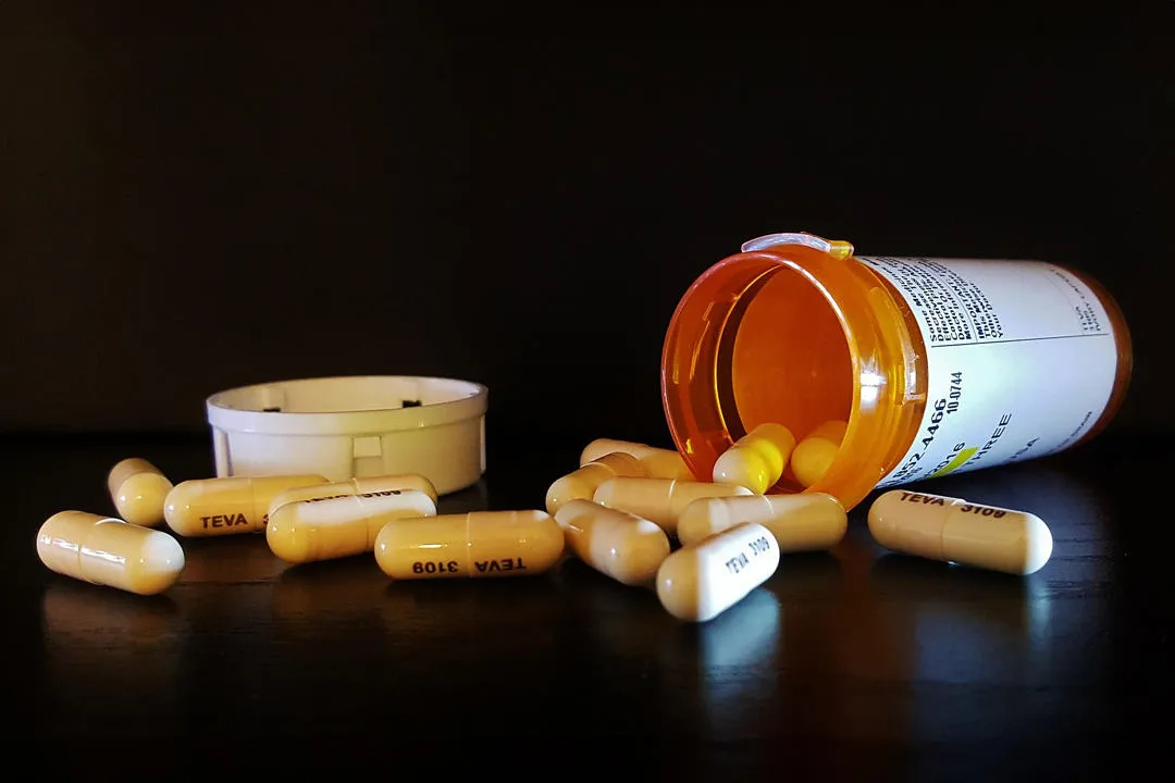 Tablets spilling out of bottle on a table