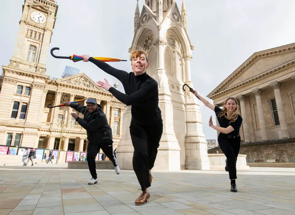 Three performers holding umbrellas participating in the Birmingham Festival 2022