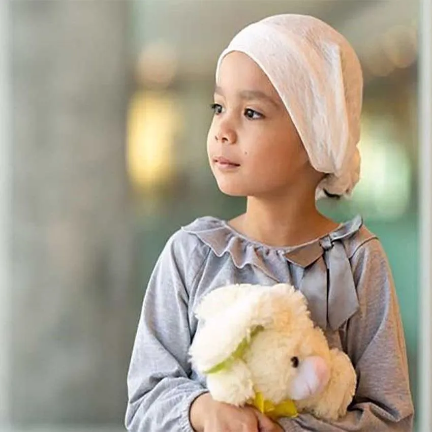 Young girl with hair covered with bandage holding a cuddly toy