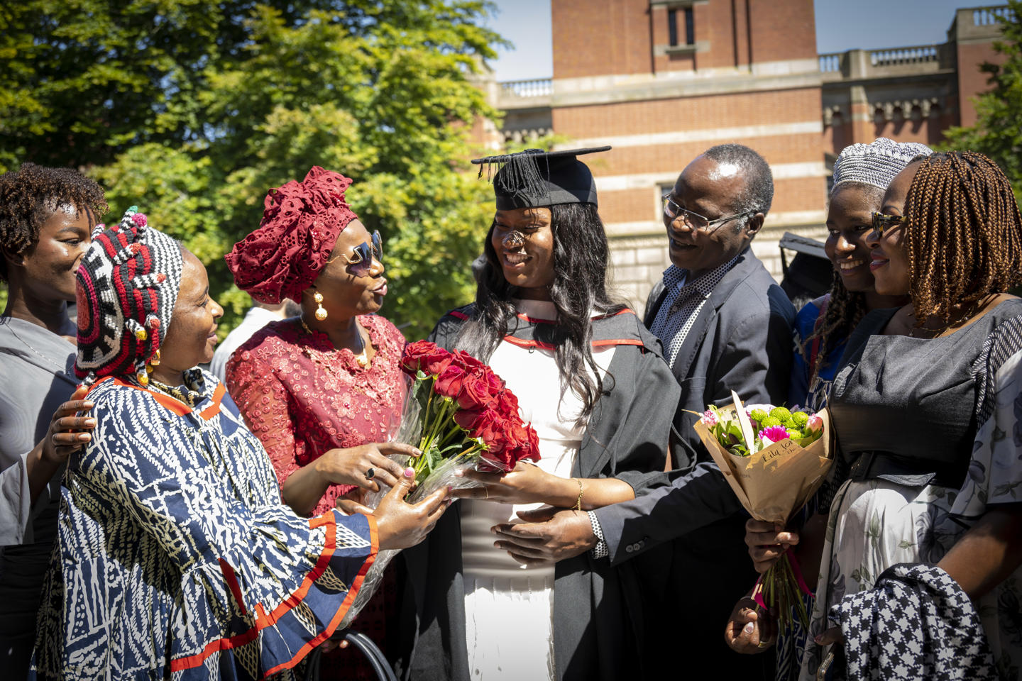 Family surrounding graduate with flowers