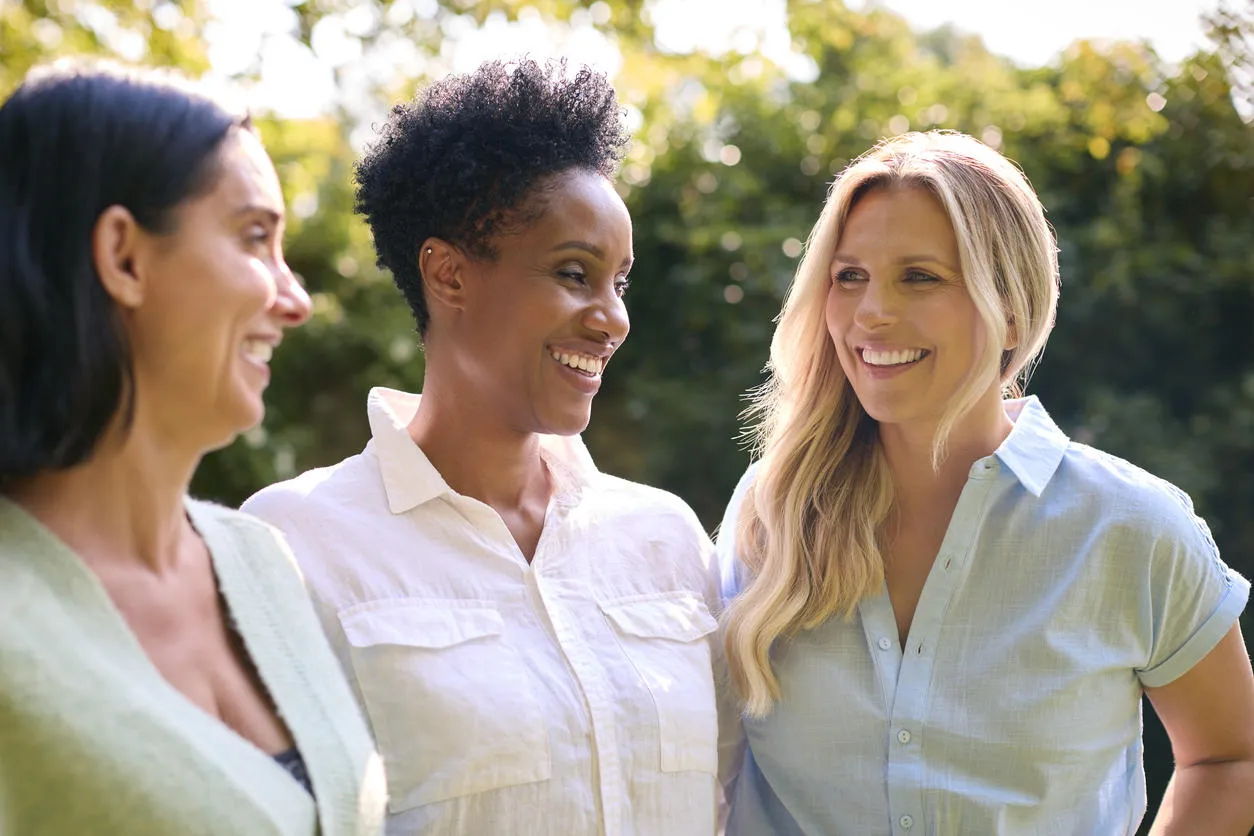 Three women standing next to each other smiling