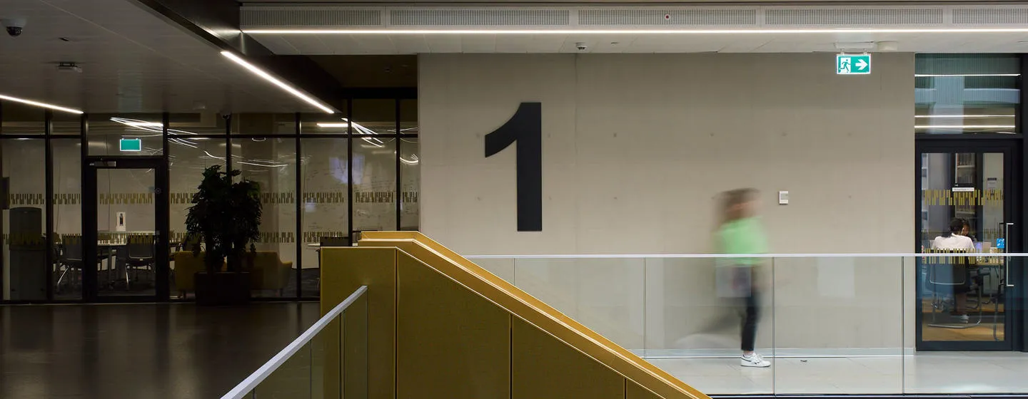 A student walks through a library atrium