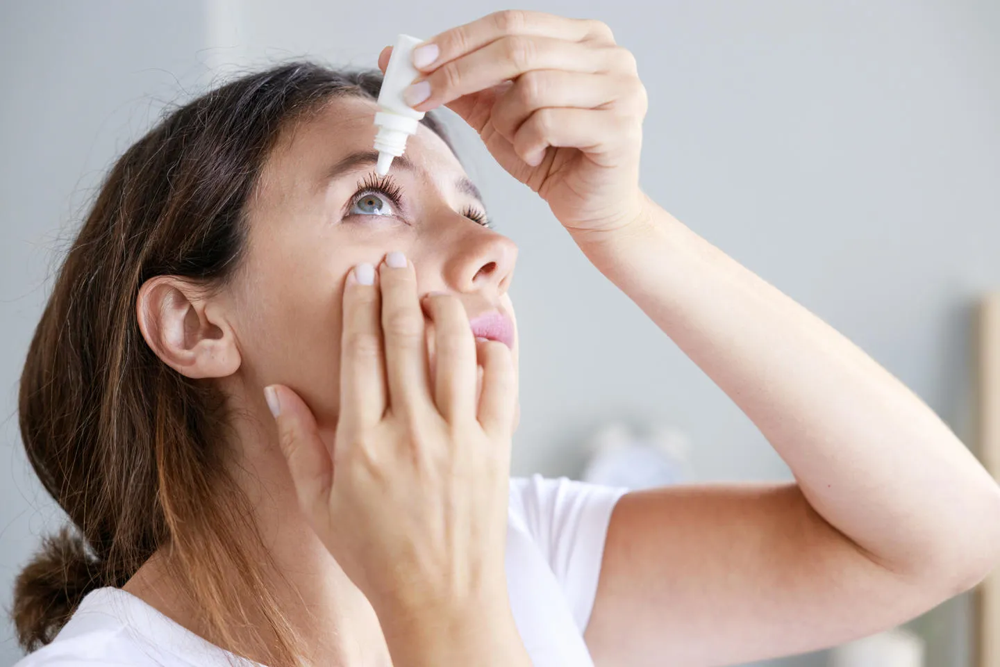 Woman using eye drops