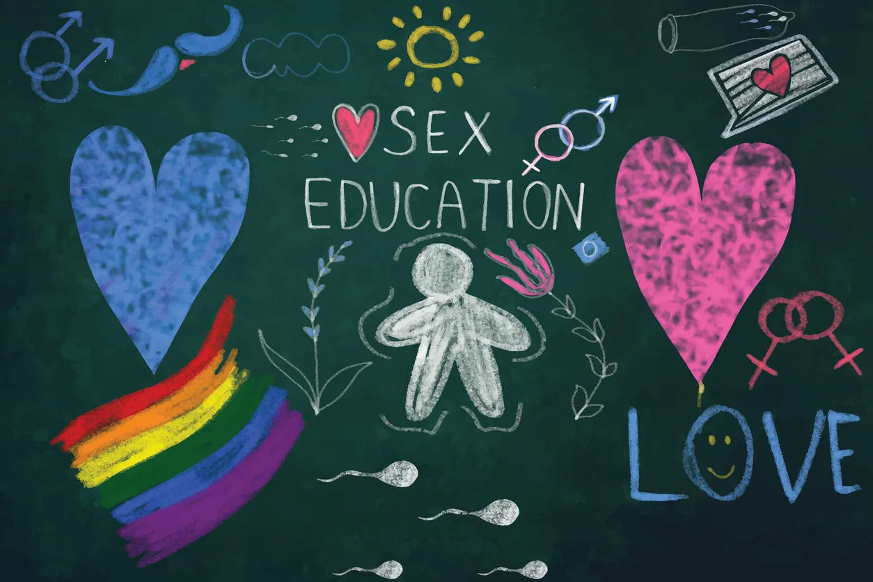 A blackboard with 'Sex Education' written on it, with chalk drawings of a person, hearts, pride flag and sperm cells.