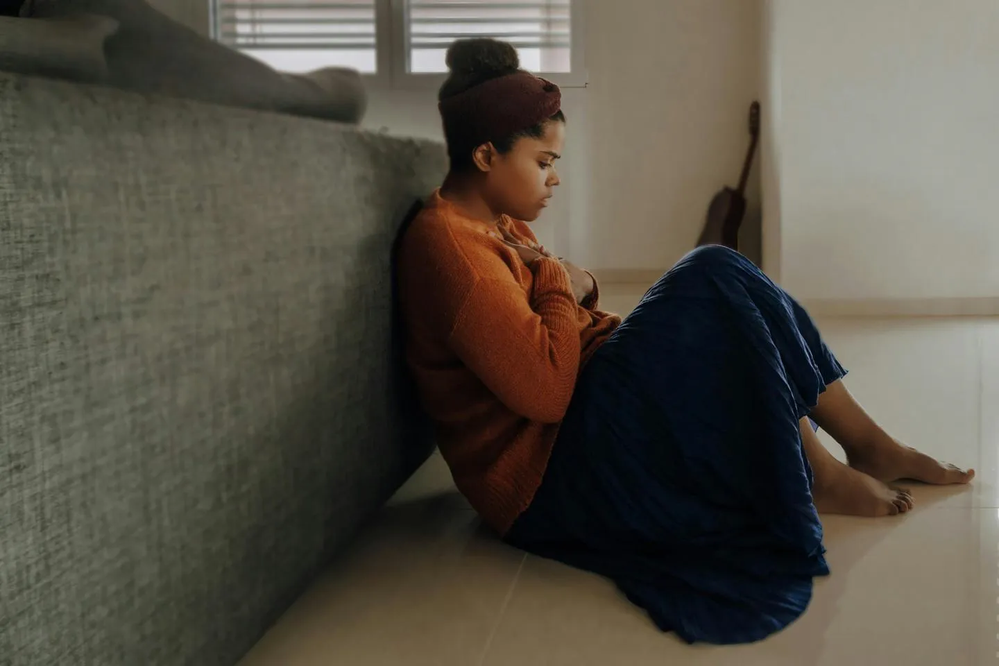 Woman sitting on floor looking sad