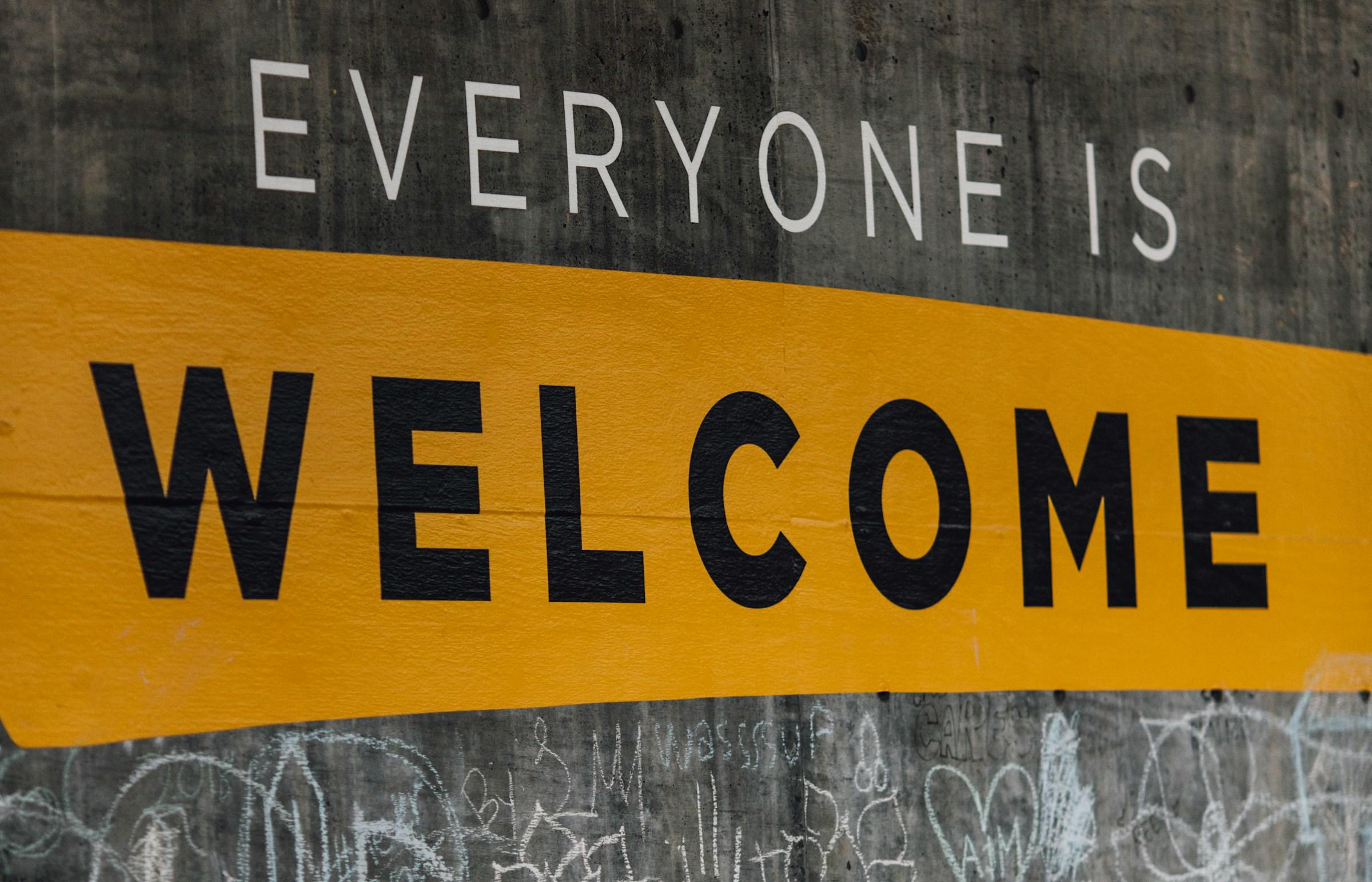 Sign painted on wall, which says: 'Everyone is welcome'