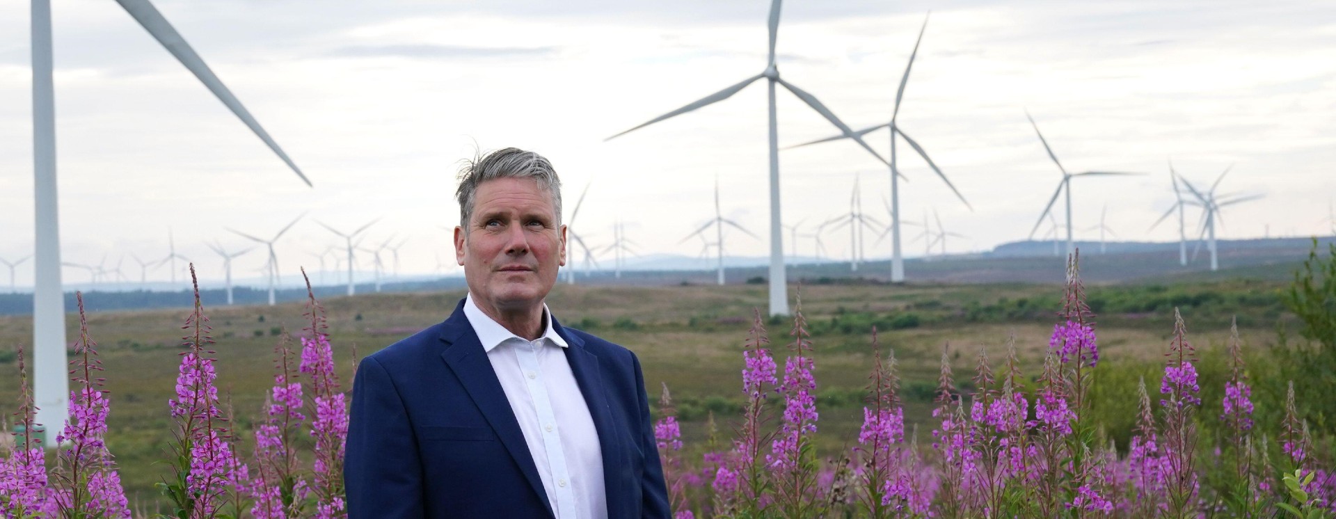 Keir Starmer standing in front of wind turbines