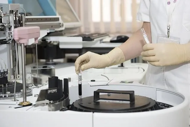 Person in laboratory with test tubes.