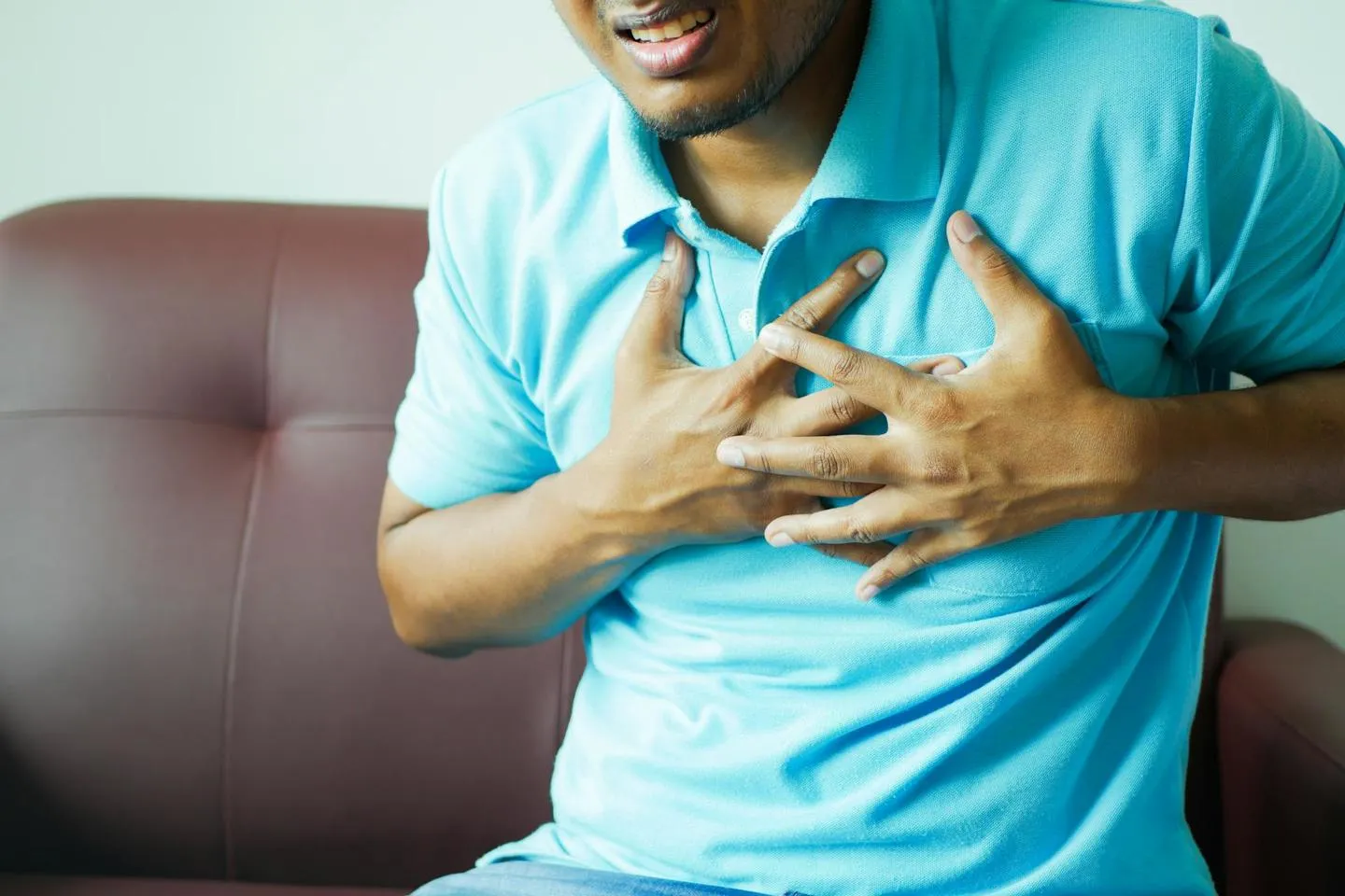 A man holding his chest while suffering an apparent heart attack