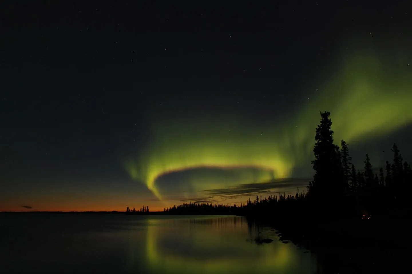 yellow lights in the sky seen across a shoreline