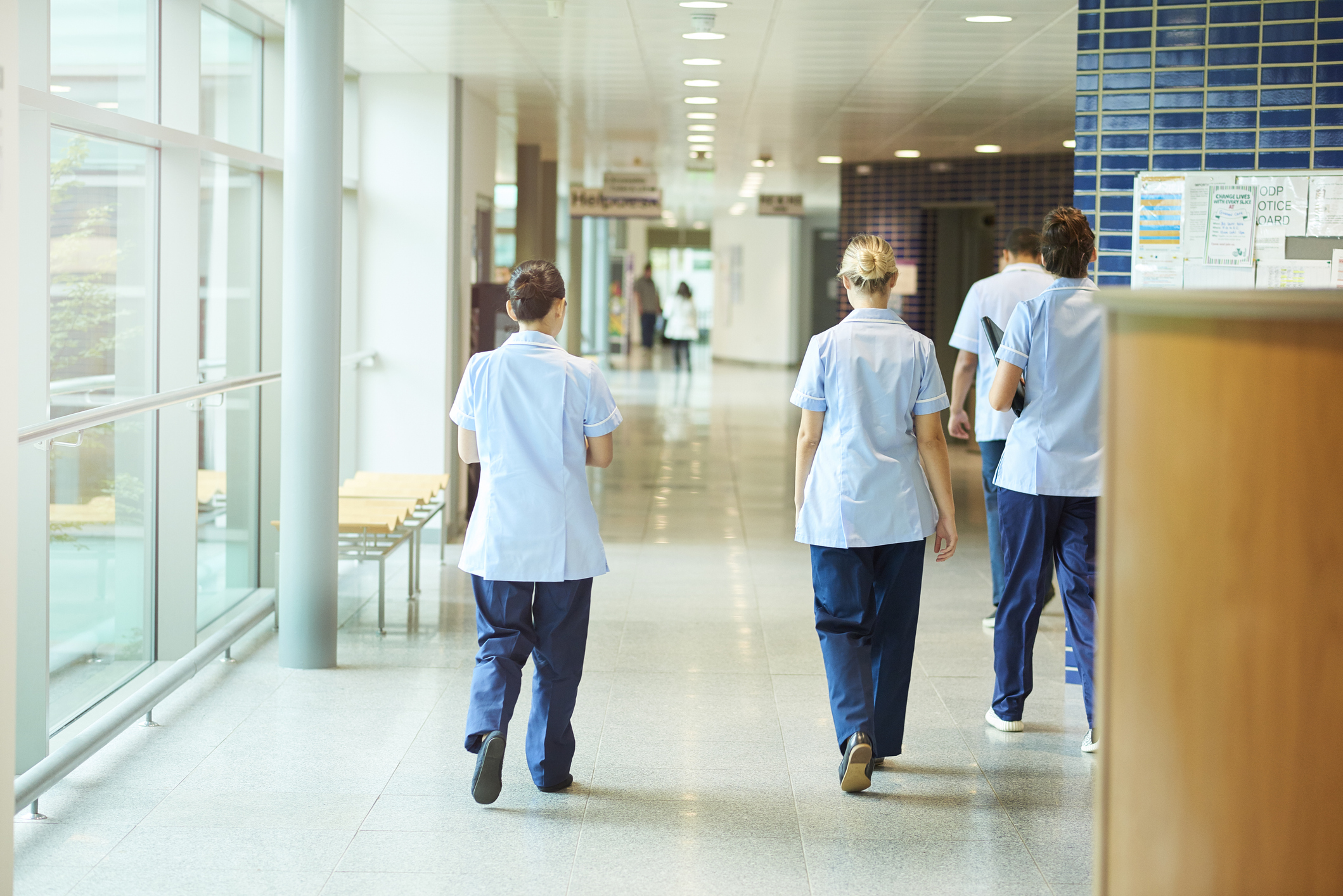 Four nurses walking along a corridor in a hospital