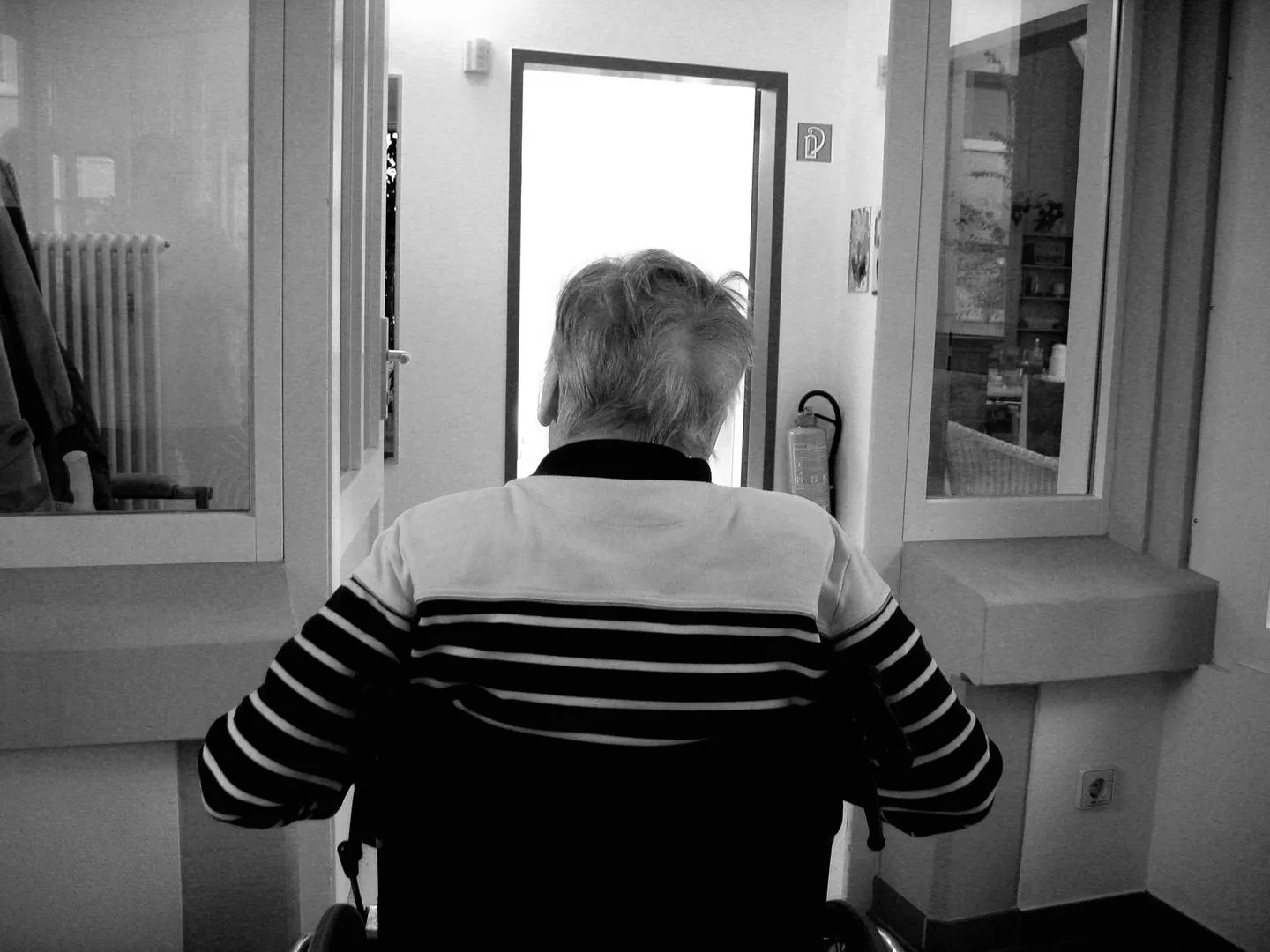 Old person looking through a doorway