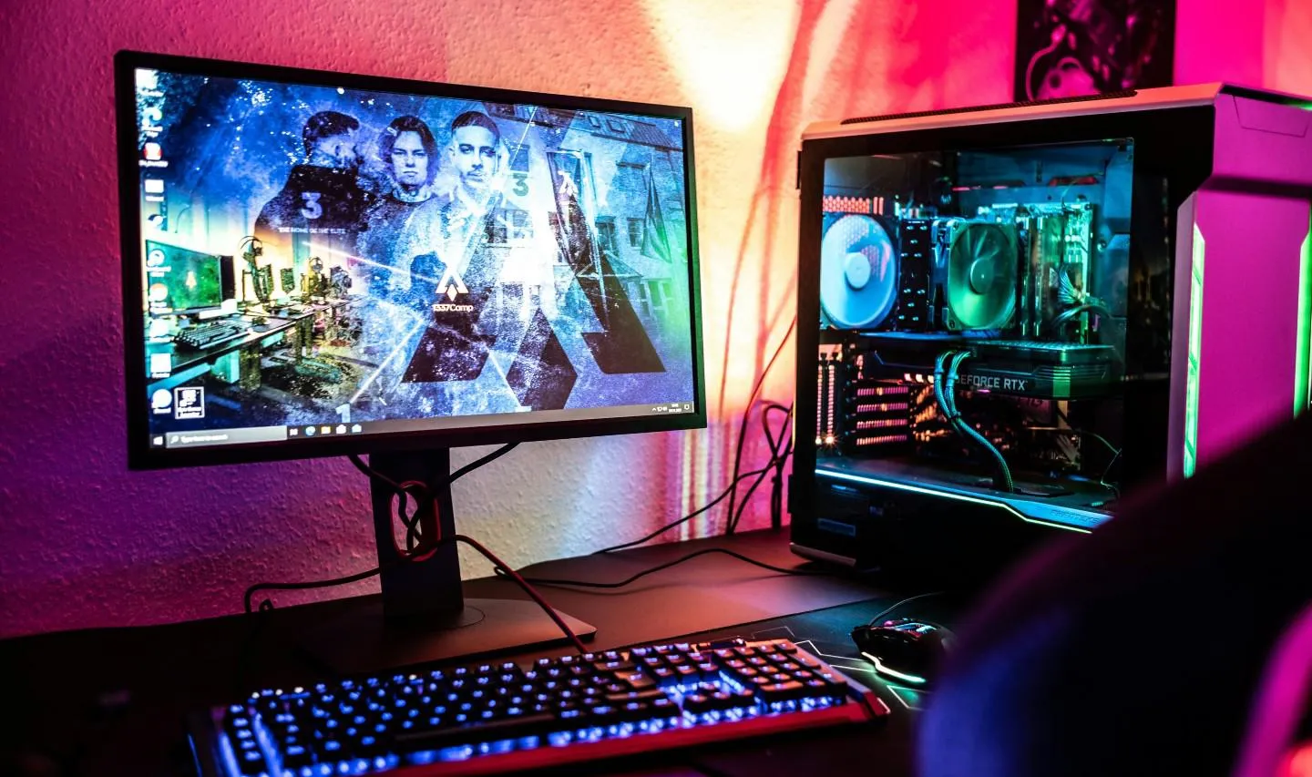 Computer on a desk against a bright coloured background