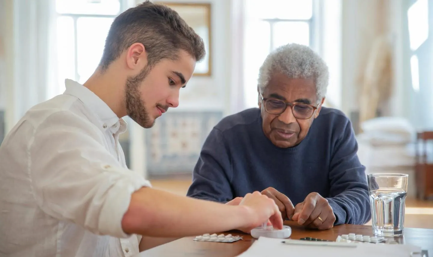 Man organises pills for elderly patient