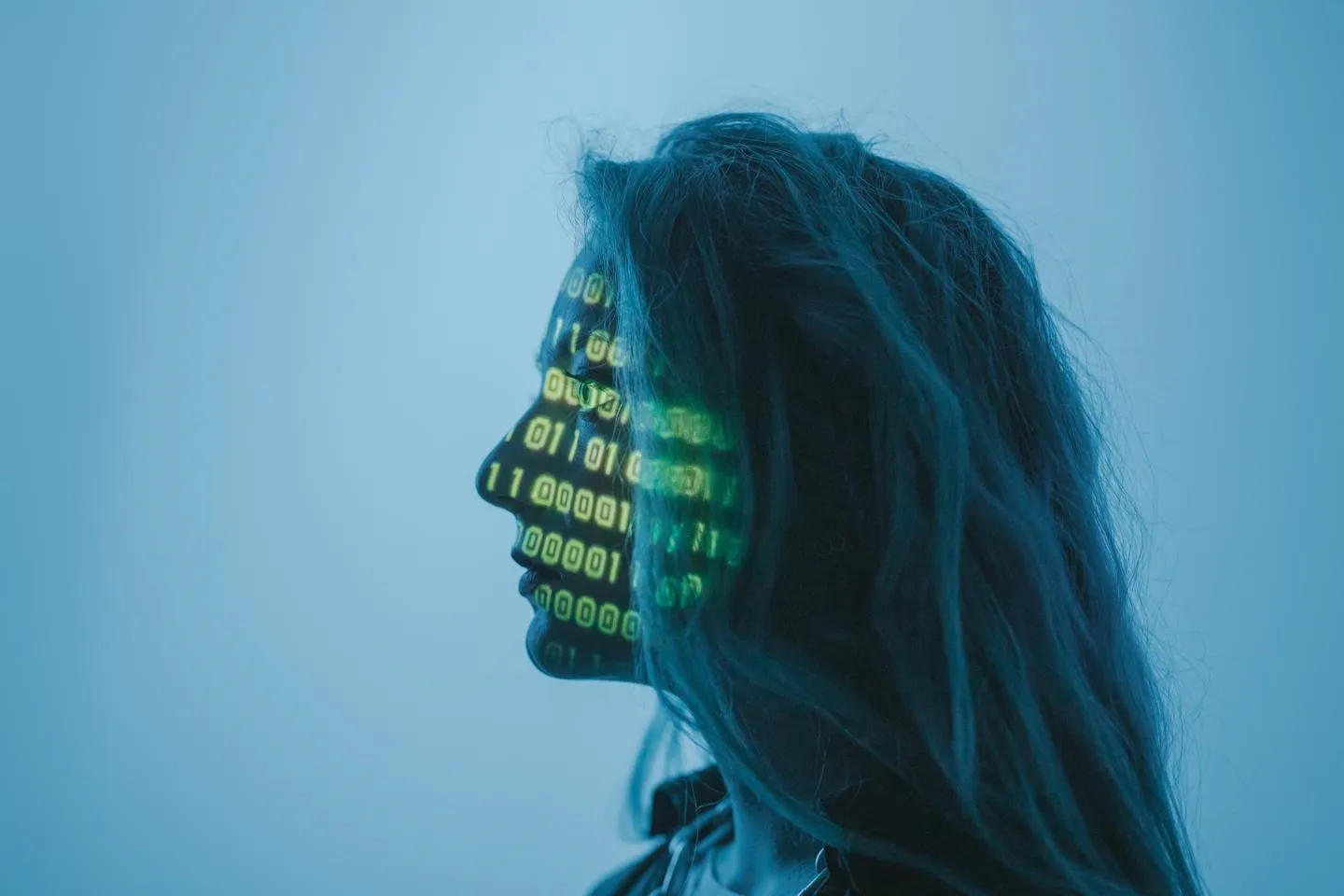 Woman looking to the left with code projected onto her face.