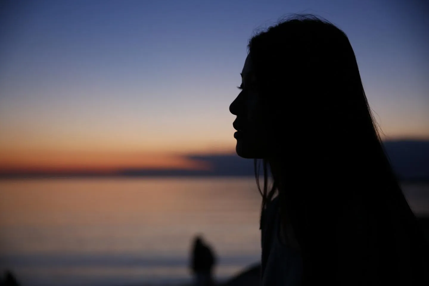 Silhouette of a girls face and ocean in the background