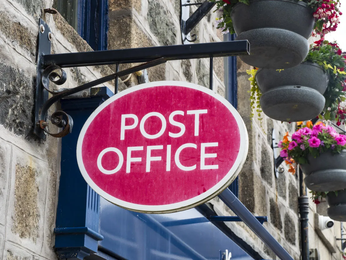 Post Office sign on a building. 