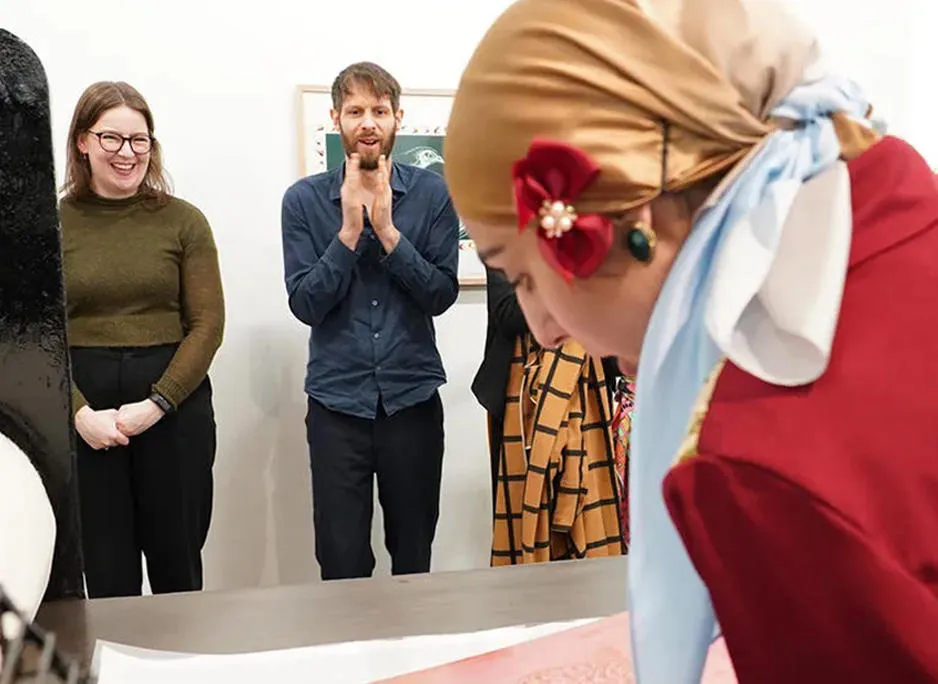 A print demonstration by Taiba Akhtar with people smiling and looking on