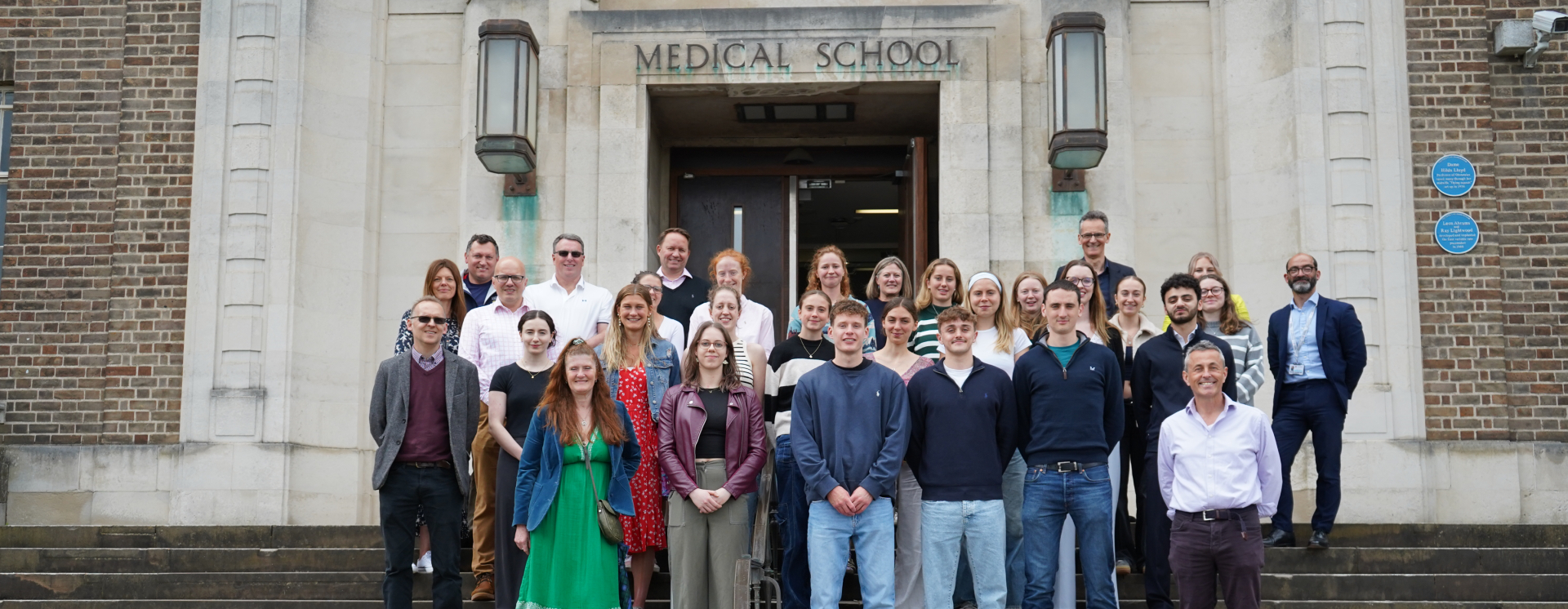 Winning students and staff celebrating the scholarship launch stood on the steps of the School of Medicine