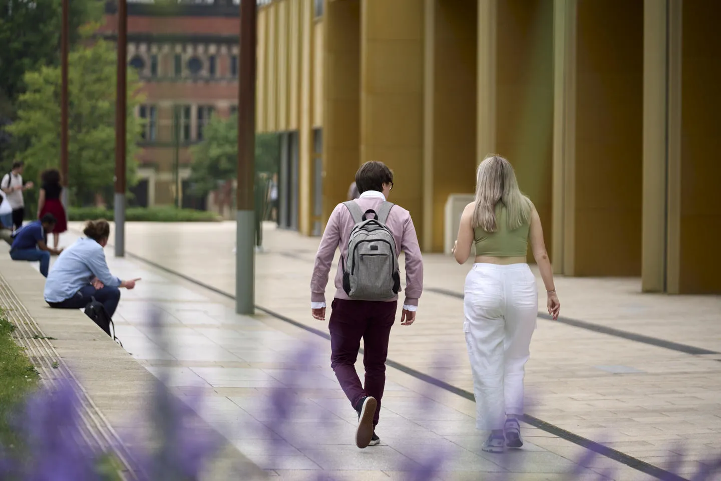 Two students walking past the Gold building - the library at teh University of Birmingham. Walking away from the camera