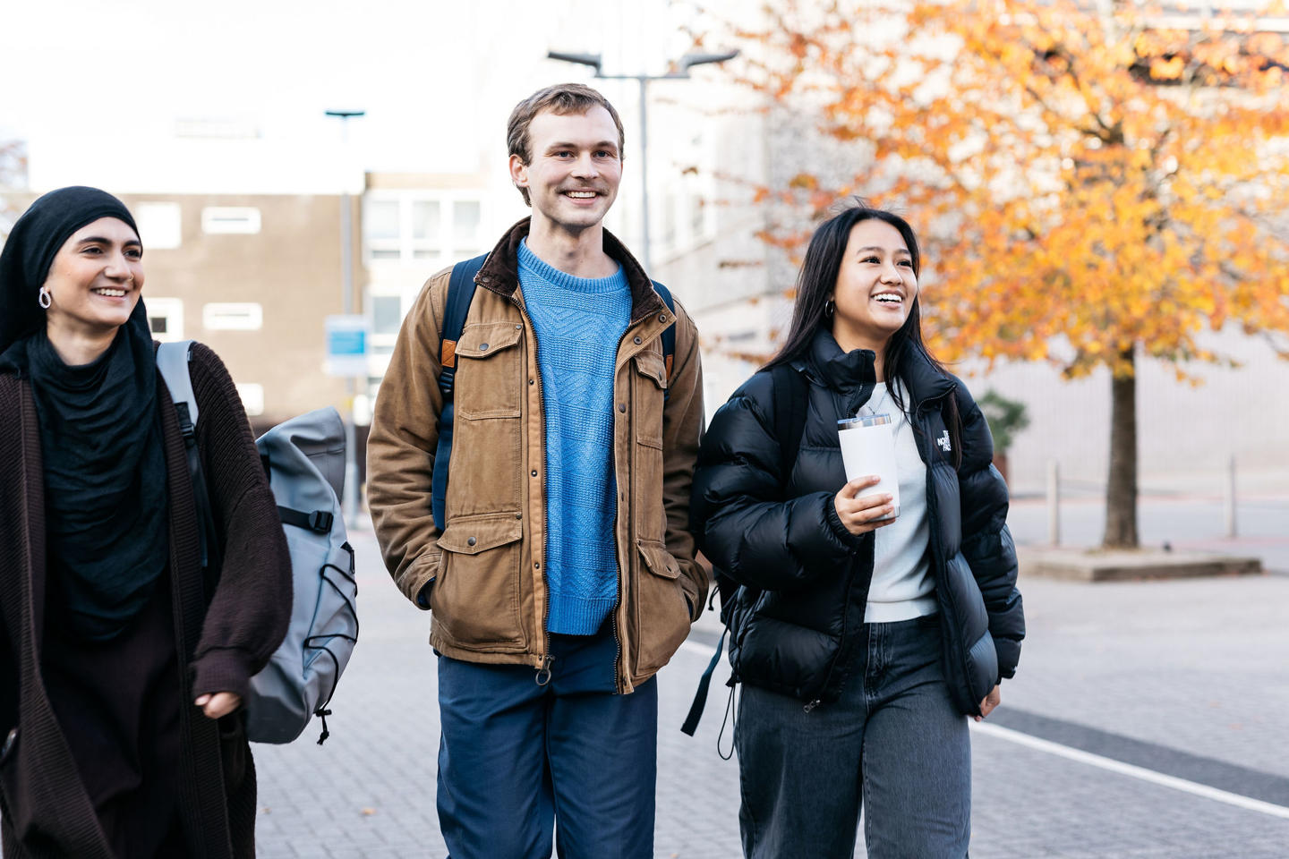 Threes students walking and smiling