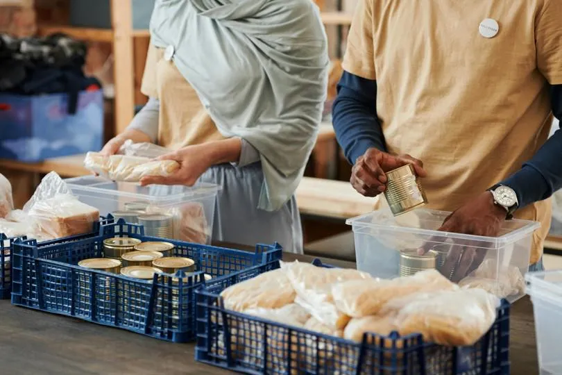 Two people volunteering at a foodbank.