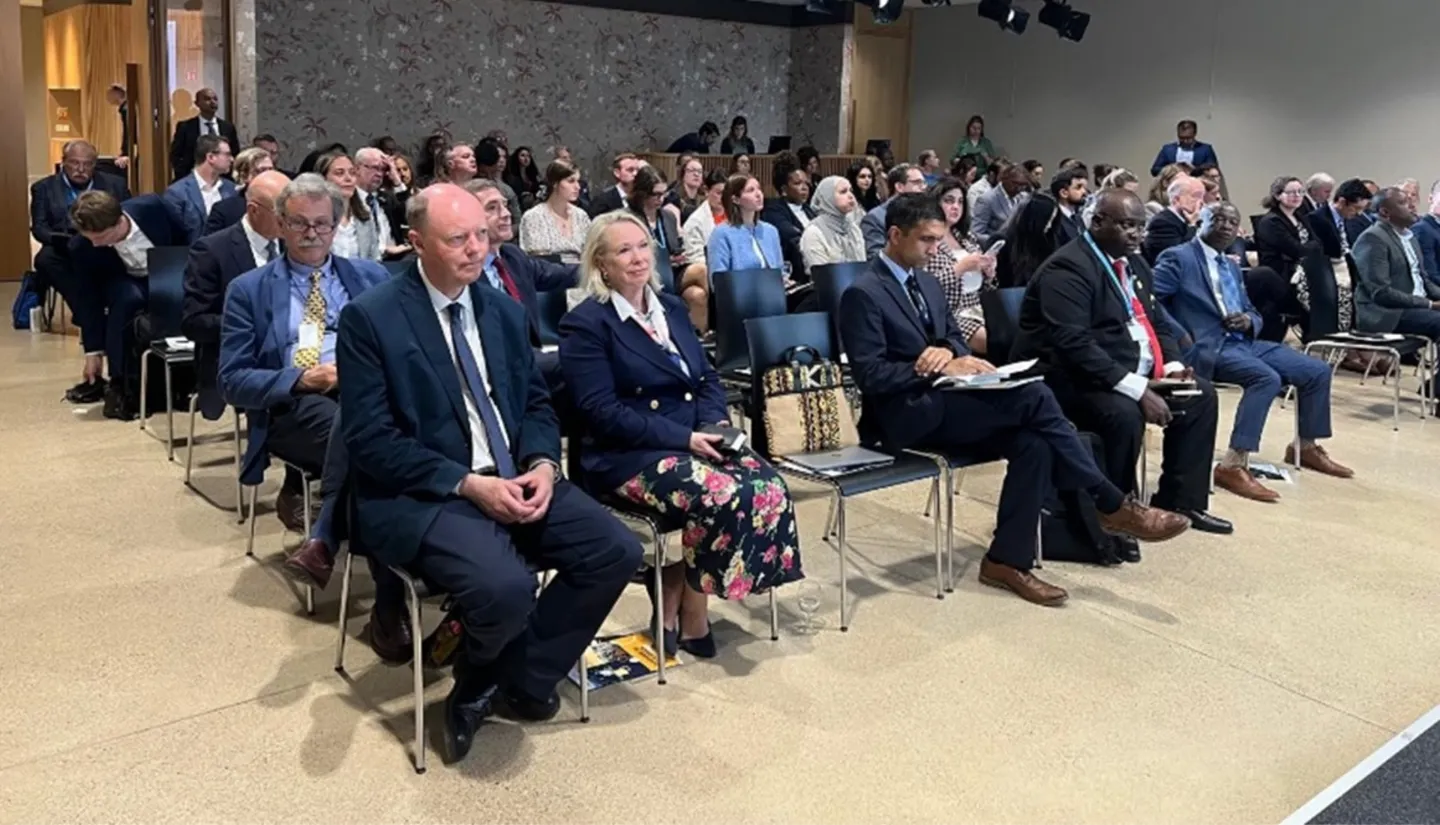 A listening audience in an auditorium with Professor Chris Whitty in the front row.