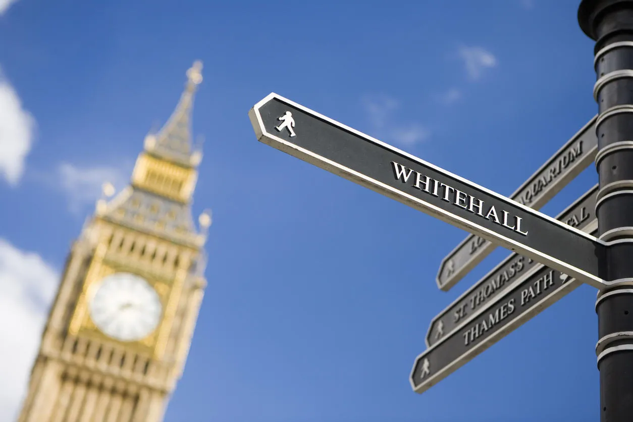 Directional sign to whitehall, with Big Ben in the background.