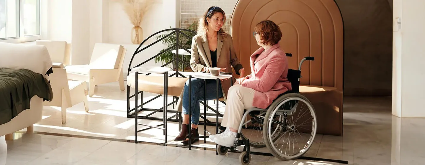 Two women talking, one of them is in a wheelchair